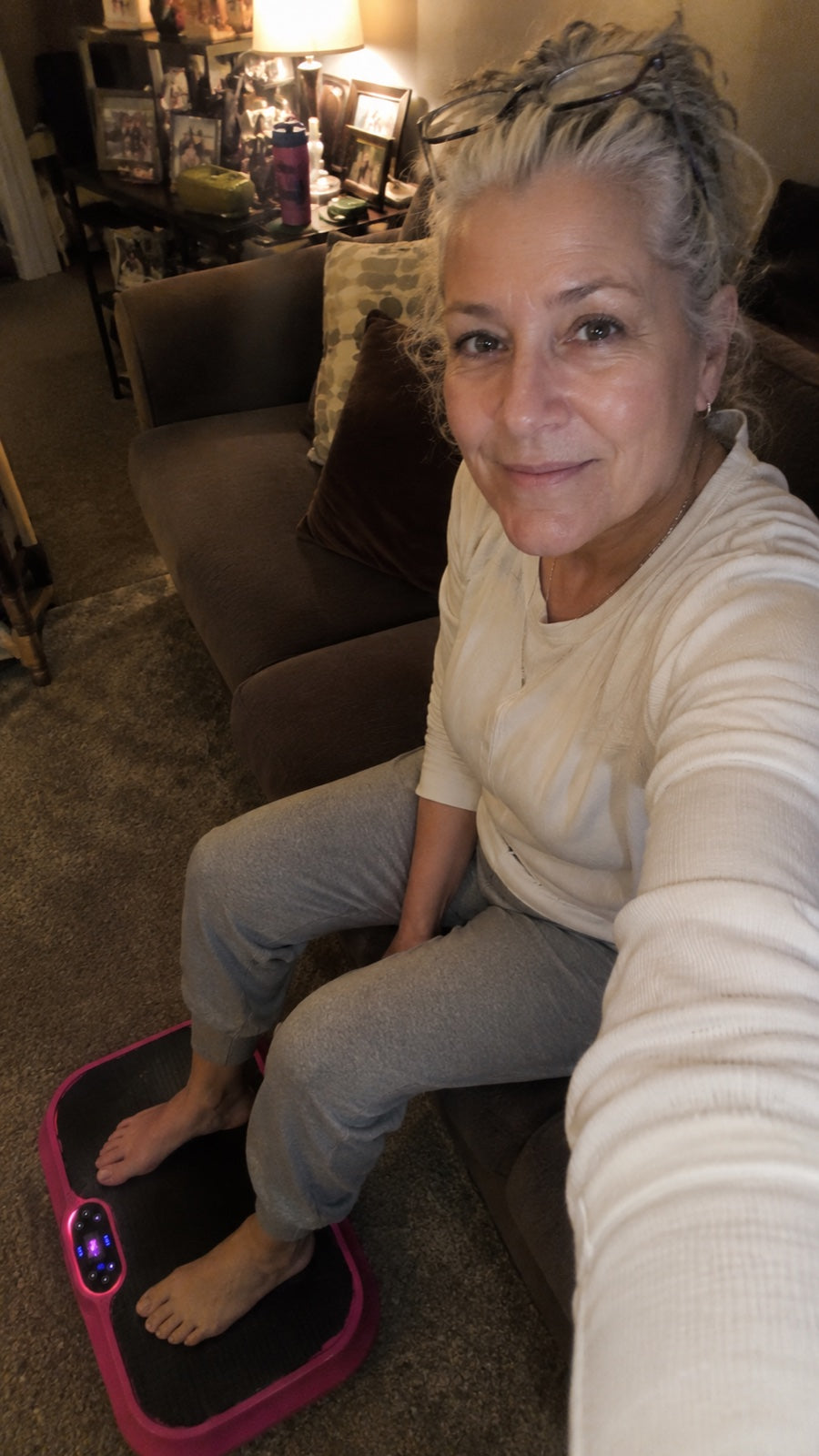Selfie from the couch with both feet on the pink Nuvé plate in a cozy living room