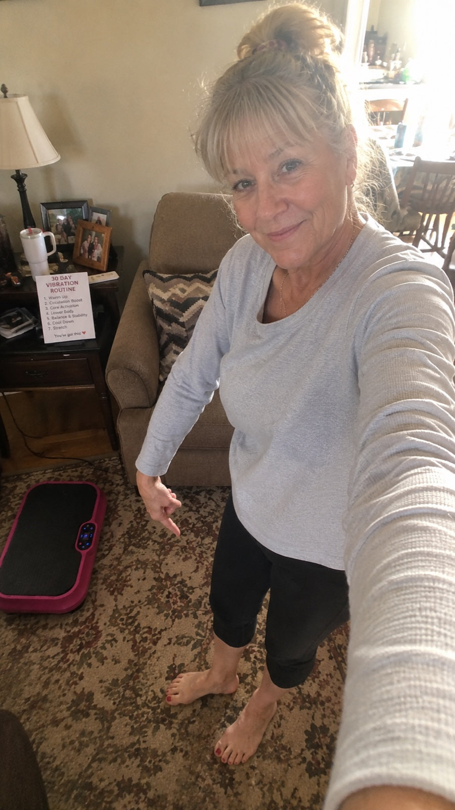 Woman pointing at the Nuvé plate next to her printed vibration routine card