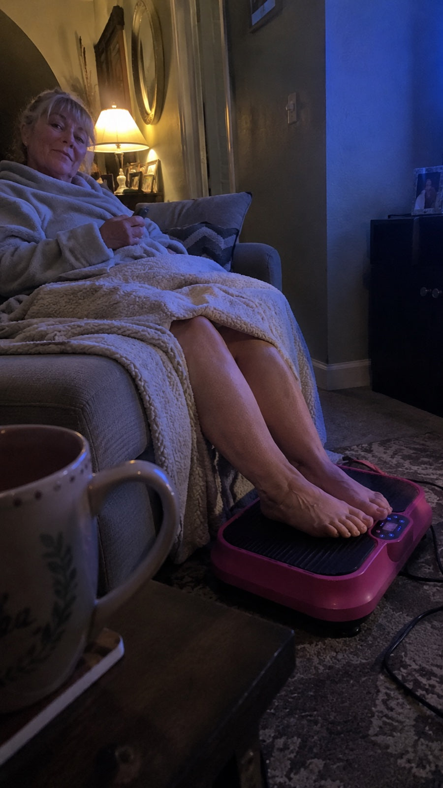 Evening on the couch under a blanket, feet resting on the Nuvé plate, tea on the side table